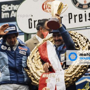 NüRBURGRING, GERMANY - AUGUST 04: Clay Regazzoni celebrates victory on the podium with Jody Scheckter, 2nd position, and Carlos Reutemann, 3rd position during the German GP at Nürburgring on August 04, 1974 in Nürburgring, Germany. (Photo by LAT Images)
