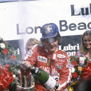 STREETS OF LONG BEACH, UNITED STATES OF AMERICA - APRIL 08: Gilles Villeneuve celebrates victory on the podium with third place Alan Jones during the USA-West GP at Streets of Long Beach on April 08, 1979 in Streets of Long Beach, United States of America. (Photo by LAT Images)